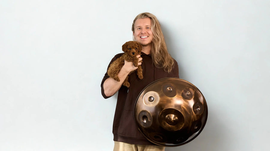 Max Neumann mit einer Handpan und Welpe Dea