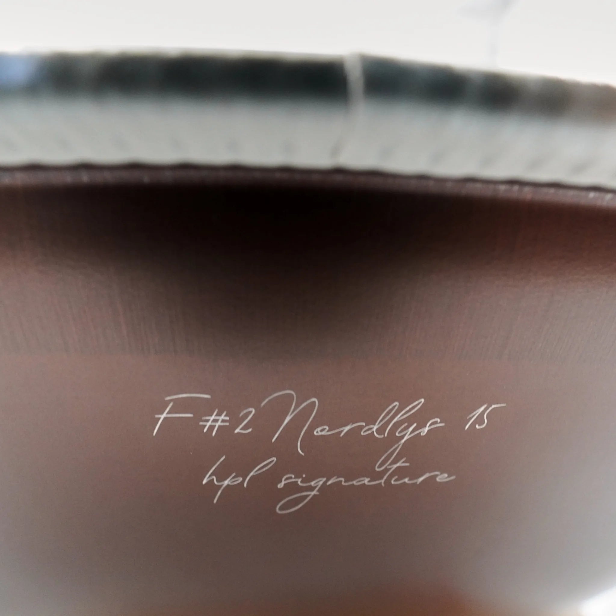 Gravur-Detail der Handpan Signature F# 2 Nordlys 15 auf mattem braunem Stahl – handpanladen
