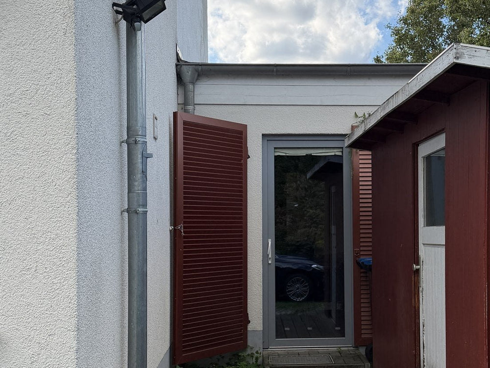 Eingang zum Handpan-Studio in Leipzig-Plagwitz, roter Holzbau mit Glastür
