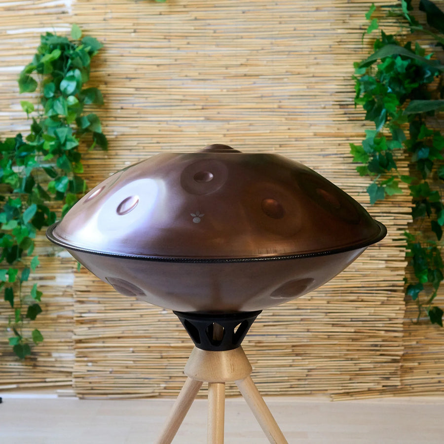 Handpan D Kurd 10 auf Holzständer, Draufsicht im Wohnambiente – kupferbraunes Finish, handpanladen