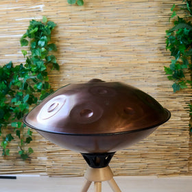 Handpan D Kurd 12 auf Holzständer, Draufsicht im Wohnambiente – kupferbraunes Finish, handpanladen
