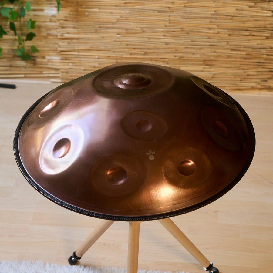 Handpan D Kurd 12 auf Holzständer im Wohnraum, schräge Draufsicht auf die Tonfelder – handpanladen