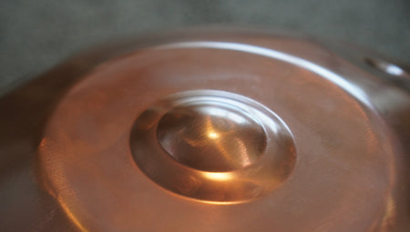 Nahaufnahme des Ding einer kupferfarbenen Handpan mit feinen Schleif- und Hammerspuren