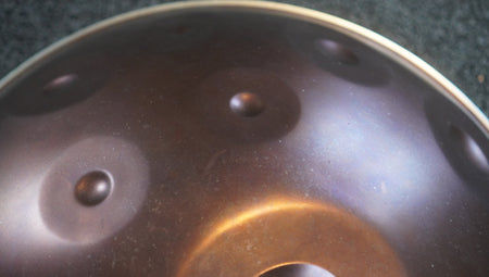 Dunkle Handpan mit Flecken, Farbverläufen und Patina auf der Oberfläche